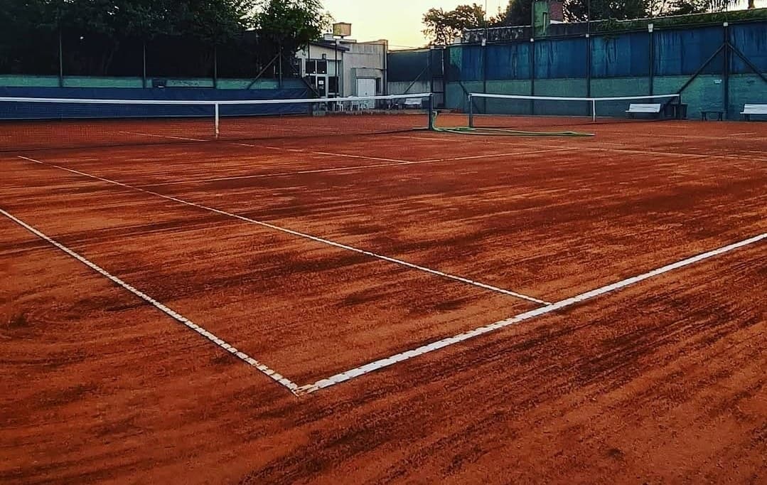 Cancha de polvo de ladrillo del club al atardecer